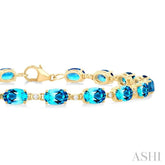 6X4 MM Oval Cut Blue Topaz and 1/6 ctw Round Cut Diamond Semi Precious Tennis Bracelet in 10K Yellow Gold